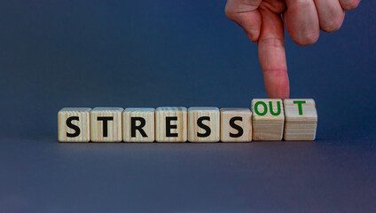 Stress or stress out symbol. Businessman turns cubes, changes words 'stress' to 'stress out'. Beautiful grey background. Medical, psychological, stress or stress out concept. Copy space.