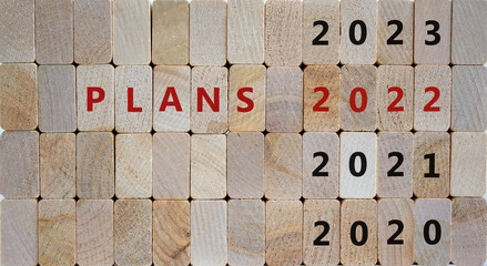 Business concept of planning 2022. Wooden cubes with words 'PLAN 2022' and numbers 2020, 2021, 2023. Beautiful wooden background, copy space. Business, 2022 plans concept.