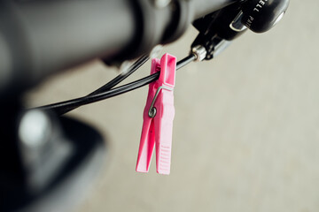 Eine rosa Wäscheklammer am Bowdenzug vom Fahrrad
