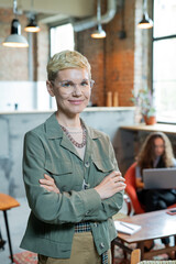 Blond successful businesswoman in elegant casualwear standing in office