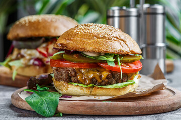 Beef Egg and Bacon Burger Served in Restaurant. American fastfood. Tasty Gourmet on Wooden Table.Beef burgers on wooden plate