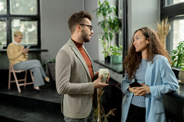 Two young managers talking at break in office environment