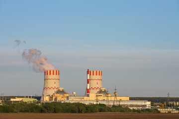 Nuclear power plant emissions of steam in the air atmosphere. Industrial zone with power station...