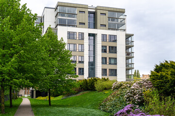 Cityscape of a residential area with modern apartment buildings, new green urban landscape in the city, green trees and flowers in garden