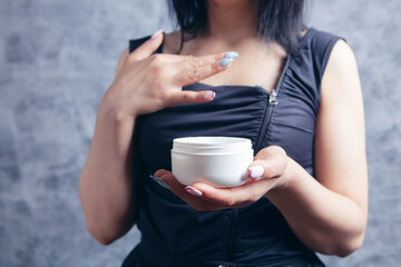 young woman holding cream in her hands