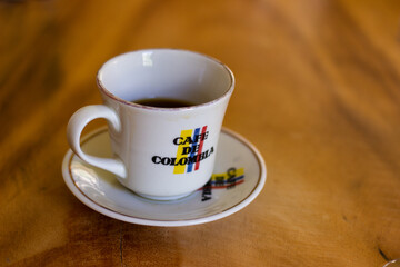 Cup of organic coffee on a wooden table from Colombian brand 
