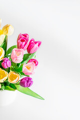 Beautiful yellow purple tulips on a light background. Fresh spring flowers. Copy space for text. Top view floral summer concept. Vertical photo.