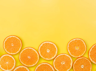 sliced fresh orange on yellow background