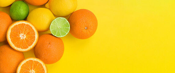 orange, lemon and lime on a yellow background. summer citrus fruit background