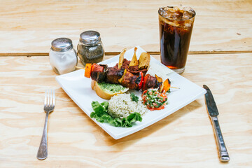 carne asada en pincho con arroz frijoles y chismol y refresco