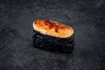 Baked Sushi Rolls with seefood on dark stone background. Hosomaki sushi with kani