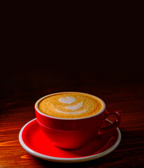Coffee in red cuo on table in dark lobby with a lot of copyspace on top