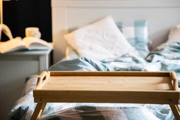 Fototapeta na wymiar cozy bedroom detail focus on wooden breakfast tabletop