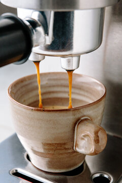 Drips of espresso into espresso cups