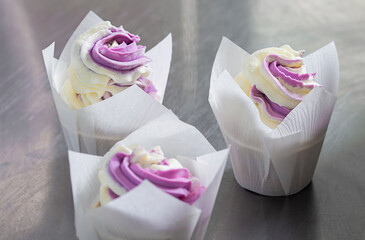 Cupcakes decorated with pink butter cream and fresh berries