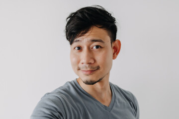 Selfie photo of Asian man in blue t-shirt isolated on white background.