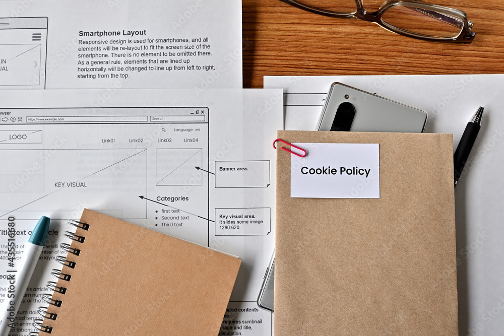 Poster there is card with the word cookie policy on it with dummy paper of design of web systems.