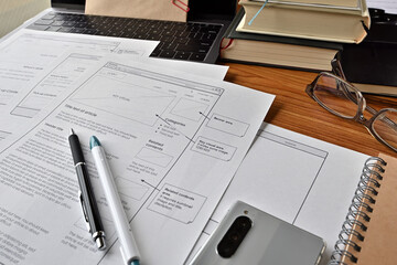 On the desk where I am doing web design. There is a wireframe printable and a pen.