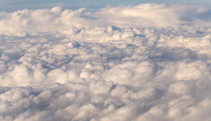 Naklejka premium Stratosphere, a view of clouds from an airplane window. Cumuliform cloudscape on sky. Flying over the land.