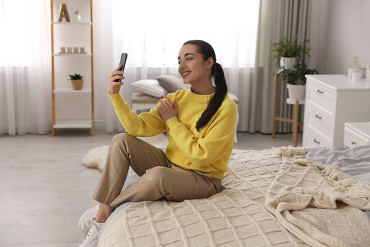 Young woman taking selfie at home in morning