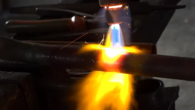 Close-up of autogenous welding of copper pipe, urgent repair welding of malfunctional home central heating system