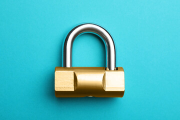 Modern padlock on light blue background, top view