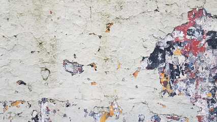 Old peeling wall, with several layers of damaged paint, of various colors