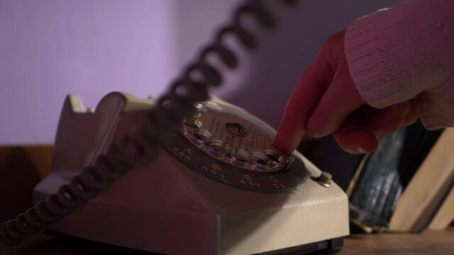 Woman dialing number on vintage retro through view of coil
