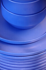 Close-up view of stacked blue ceramic plates and bowls