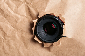 Hidden camera lens through hole in paper. Space for text