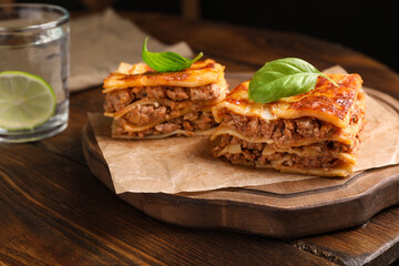 Delicious lasagna served on wooden table, closeup