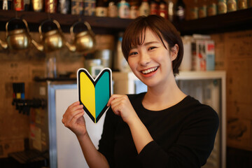 初心者マークを持つ女性店員