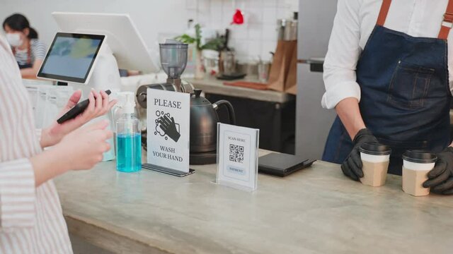 Close-up shot of waiter handing QR code to customer scan for payment.
