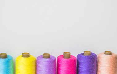 Spools of colorful threads on a white background, copy space 