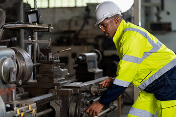 African American male engineer worker maintenance heavy machine in the factory. Black male worker working with heavy machine with safety uniform, goggles and helmet