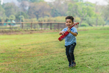 mixed race caucasian and asian boy having fun playing in park