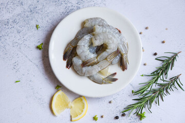 Shrimp peeled on white plate ready for cooking with herbs and spices lemon, Fresh shrimps or prawns...