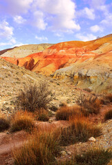 Mars in the Altai Mountains. The slope of the river terrace with the exposure of colorful clays and siltstones under the blue sky is a geological attraction. Chui Valley, Siberia, Russia