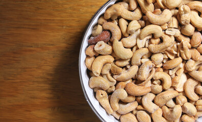 Bowl of Salted Cashews with Wooden Background