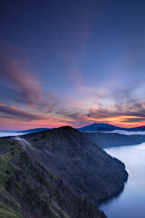 美しいグラデーションの夜明けの空と湖畔の山。日本の北海道の摩周湖
。