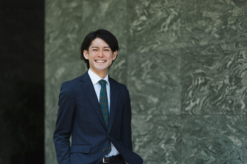 出社する若い男性・マンションのロビー背景・ビジネスイメージ