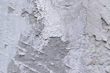 Gray wall with cement plaster. Detachments, cracks, irregularities.