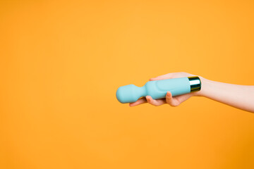 Blue vibrator or masturbation massager on an orange background. Flat Lay. Sex shop concept