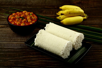 Homemade white rice puttu with chickpeas curry masala and bananas.