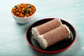 Homemade delicious vegetarian foods- steamed organic red rice puttu served with chickpeas curry masala. Kerala cuisine.