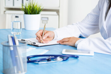 Doctor filling patient history list at clipboard