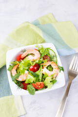 Delicious and healthy shrimp salad with herbs and tomatoes. Dietary nutrition for weight loss. Recipe for cooking fresh seafood. Mediterranean cuisine.