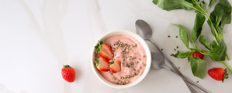 Flat Lay Bowl Of Strawberry Smoothie With Basil On Light Marble Table