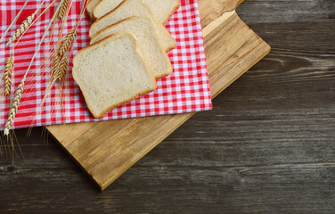 Fototapeta na wymiar White bread toast with Wheat and red tablecloth on wooden background.