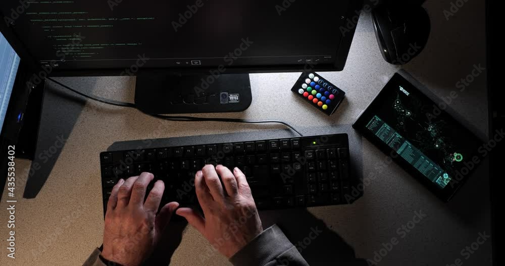 Poster hacker types as the overhead camera moves across their work area